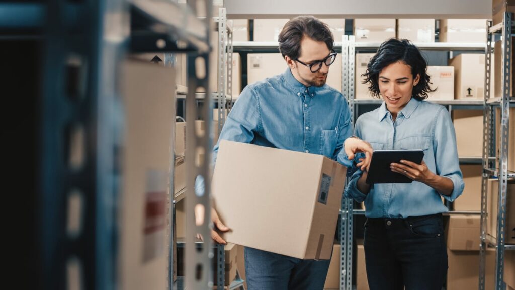 Two coworkers take inventory in a stockroom.