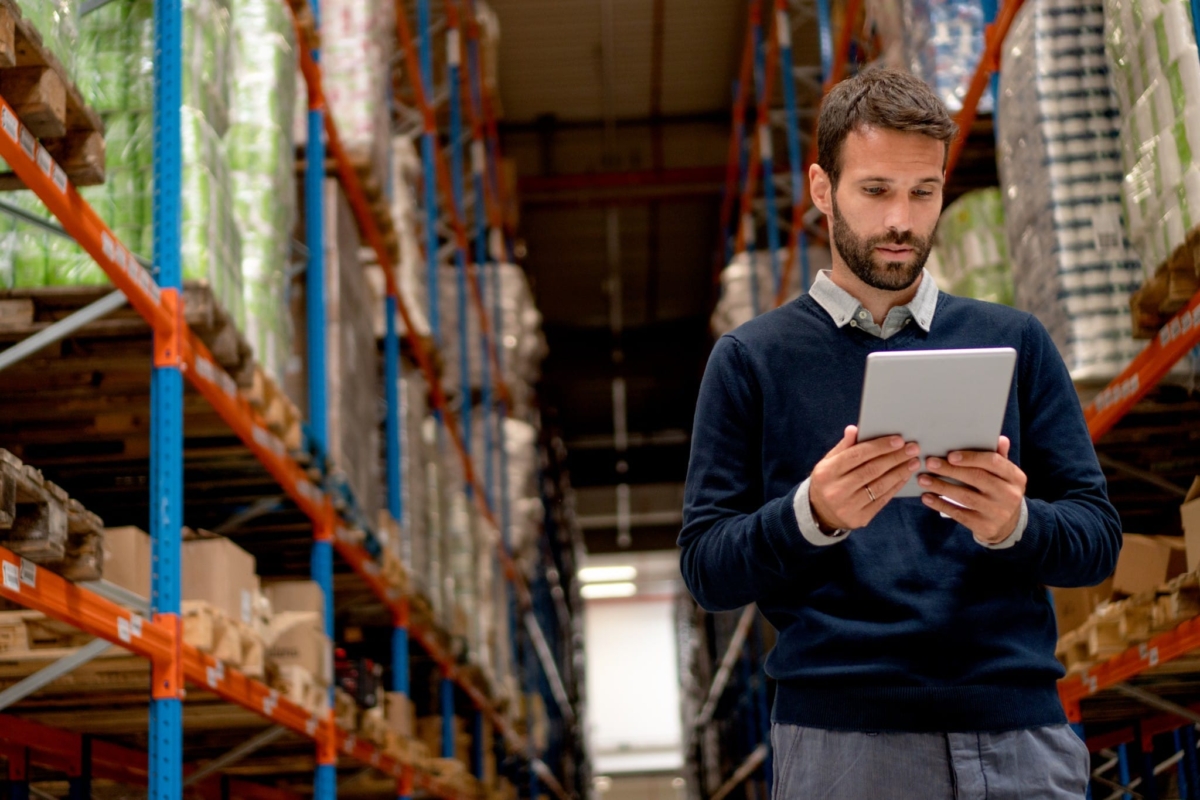 A manager uses inventory management software to keep his warehouse organized and profitable.