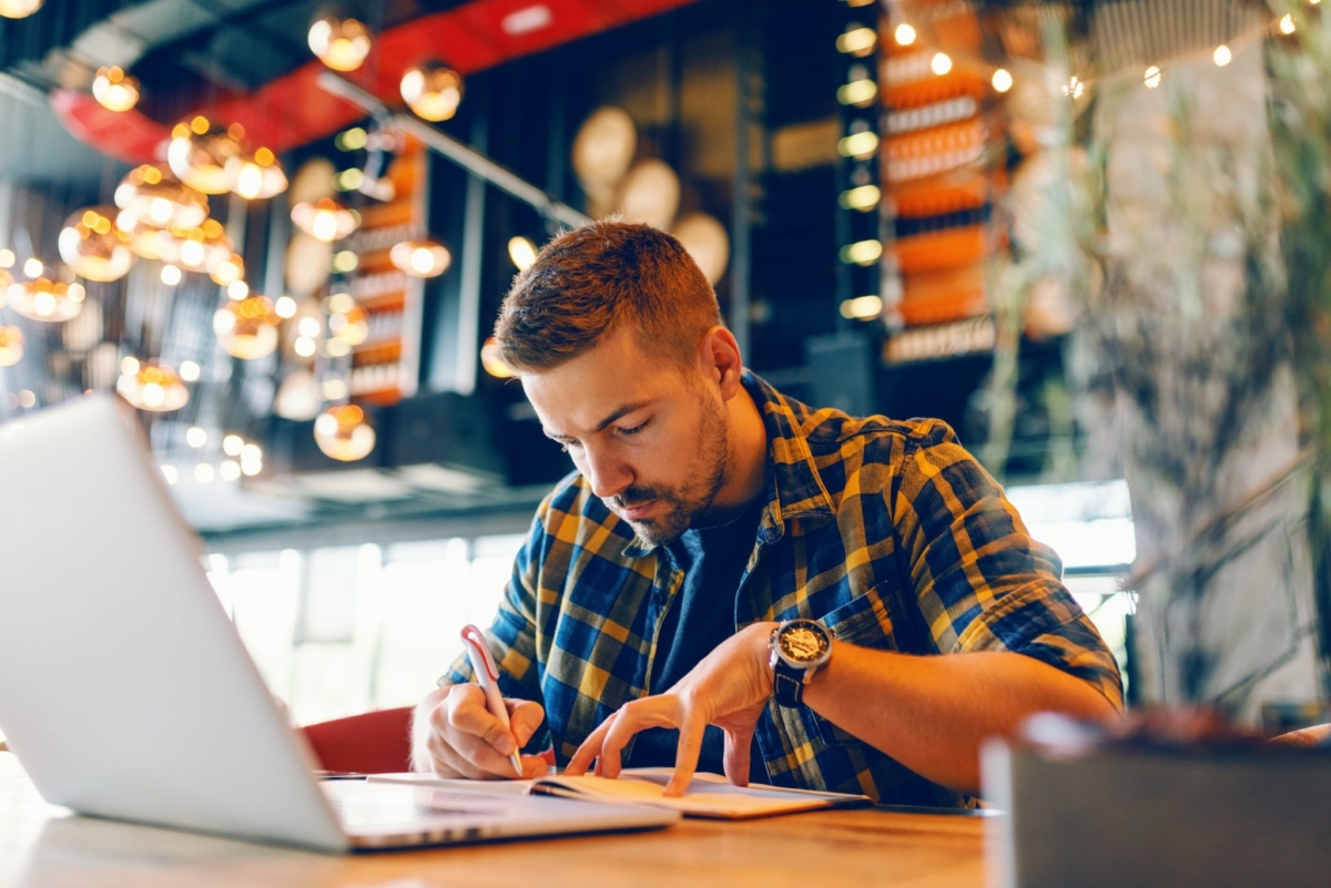 A man works on inventory spreadsheets on a laptop