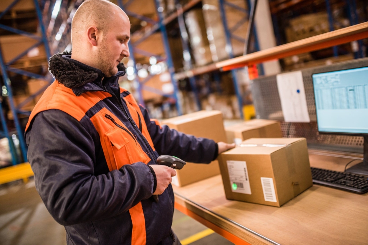 A man uses a barcode scanner to take inventory.
