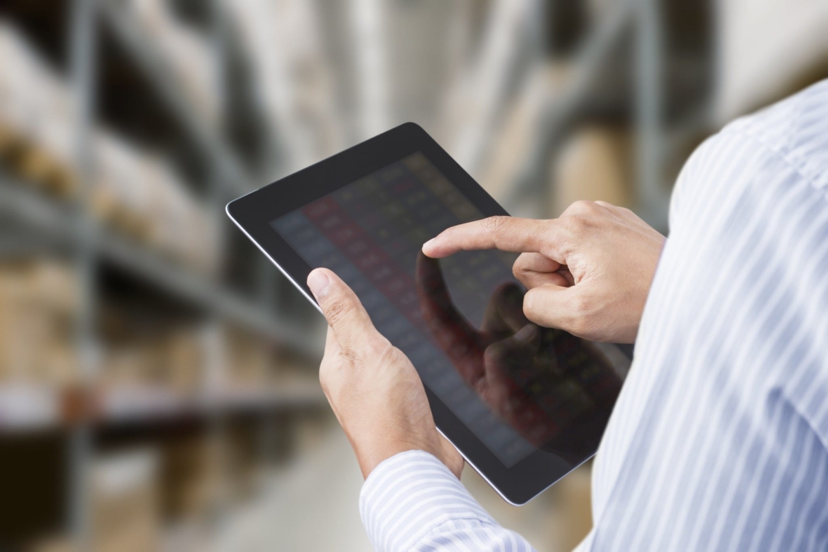 A man automating inventory on a tablet.