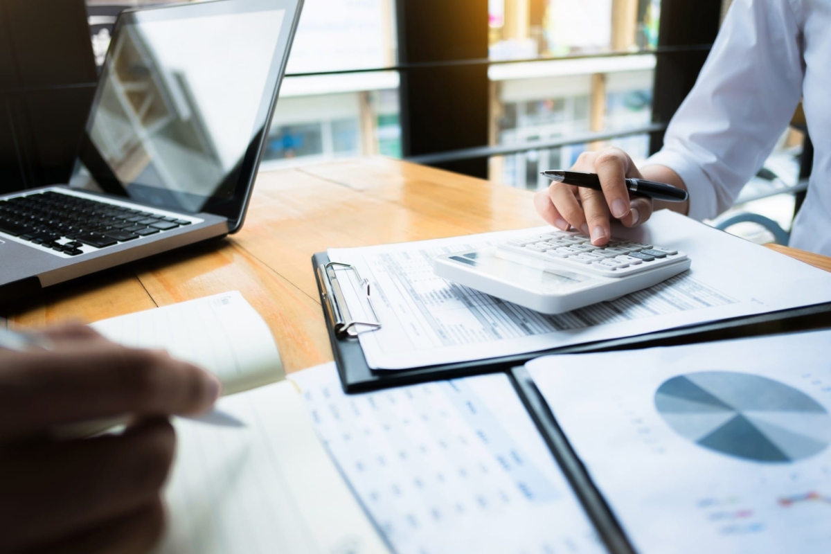 Office workers forecasting inventory at a desk.