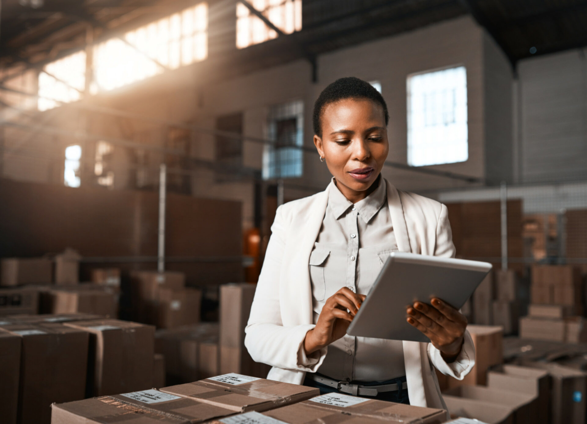 A woman in a small business takes inventory on a tablet.