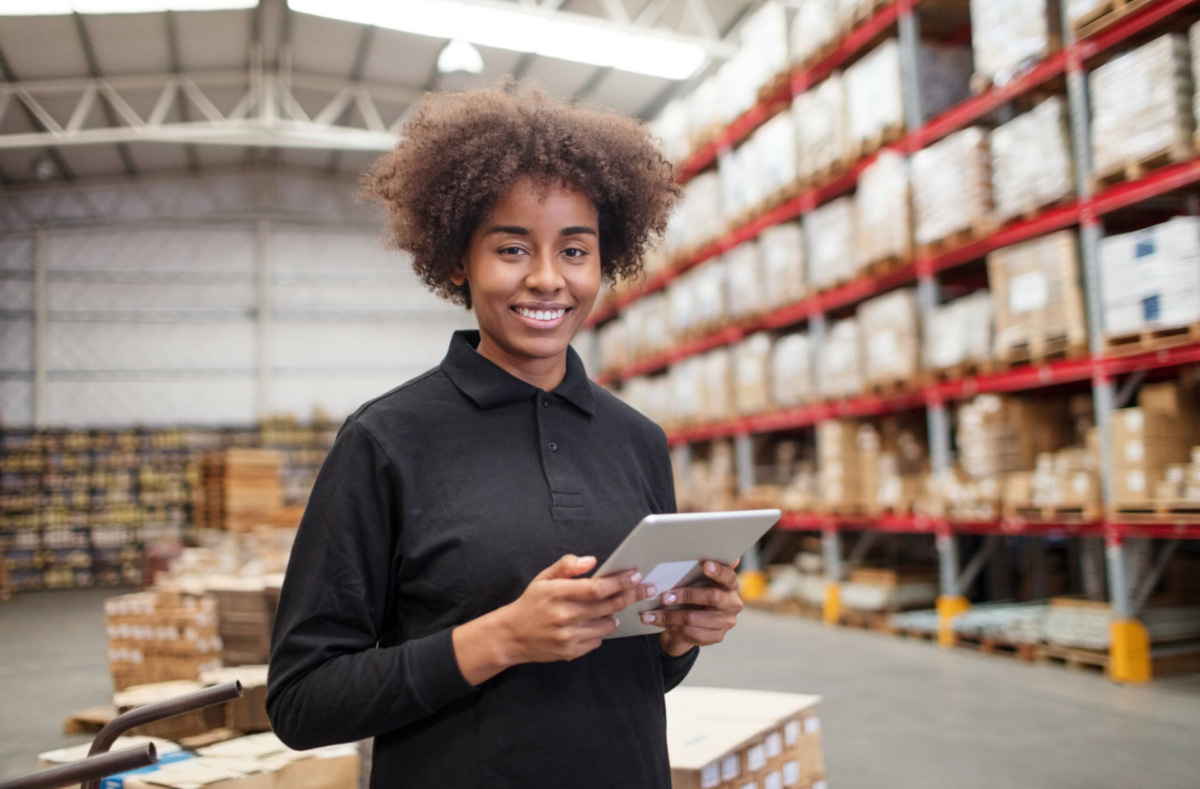 Female warehouse worker does inventory on a tablet.