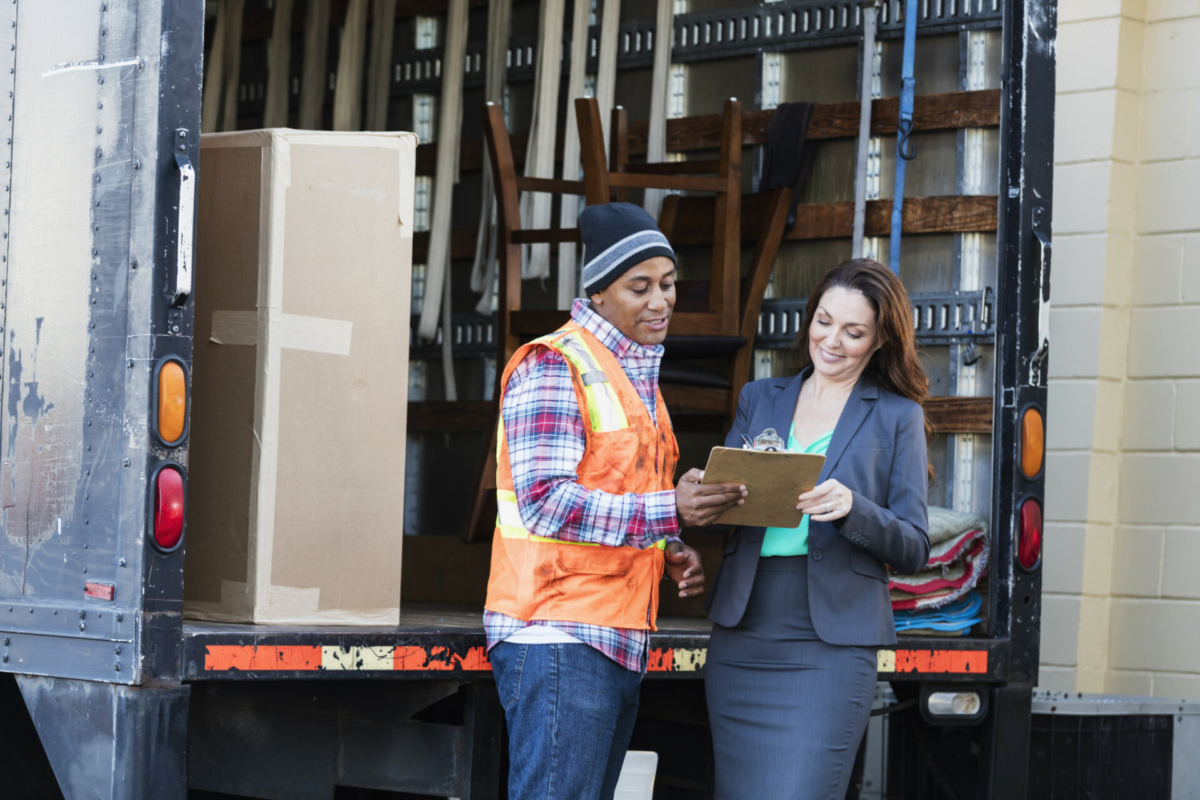 A woman in a suit receives an order from a delivery man, concluding the lead time for her product.