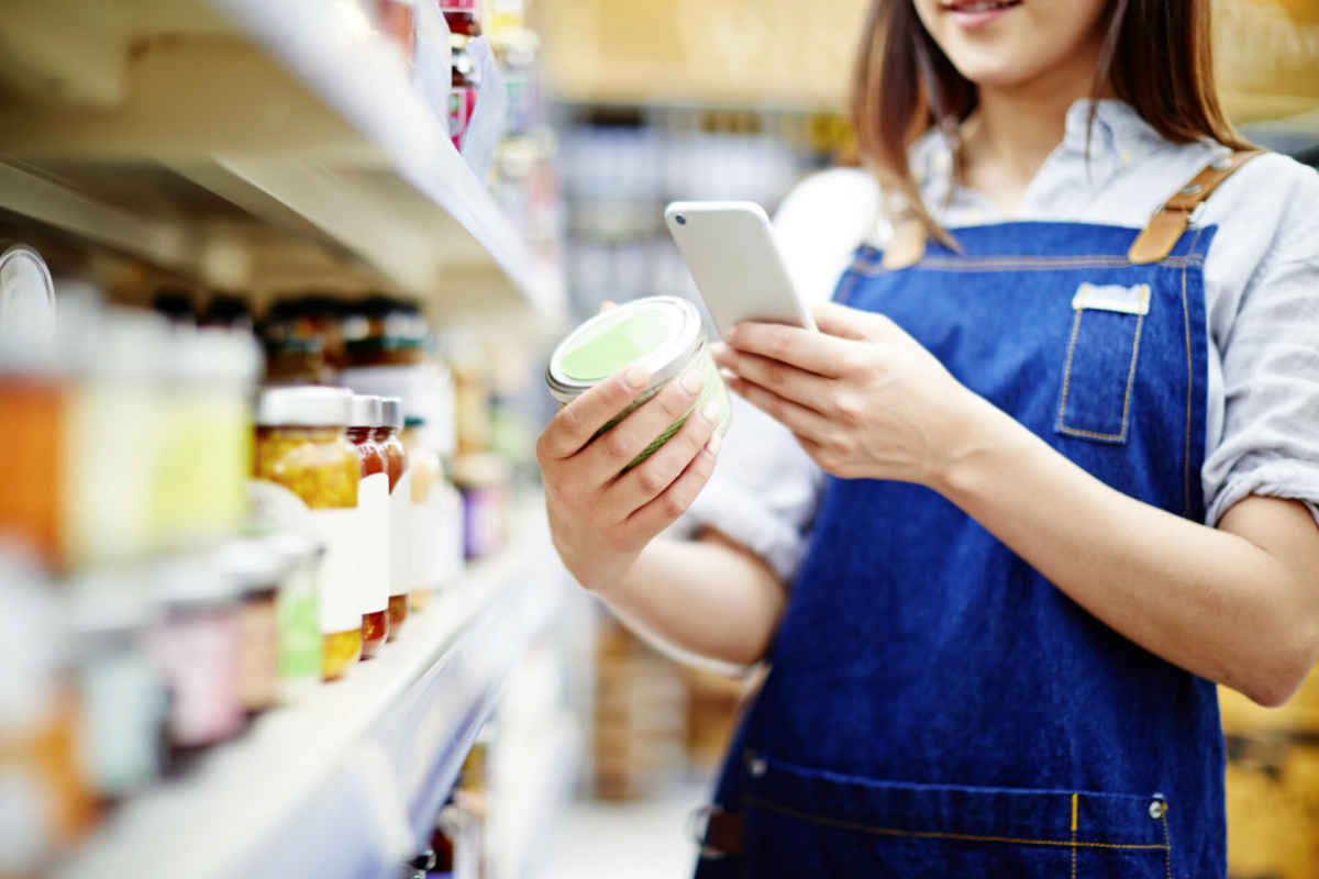 A woman scanning inventory in a grocery store.