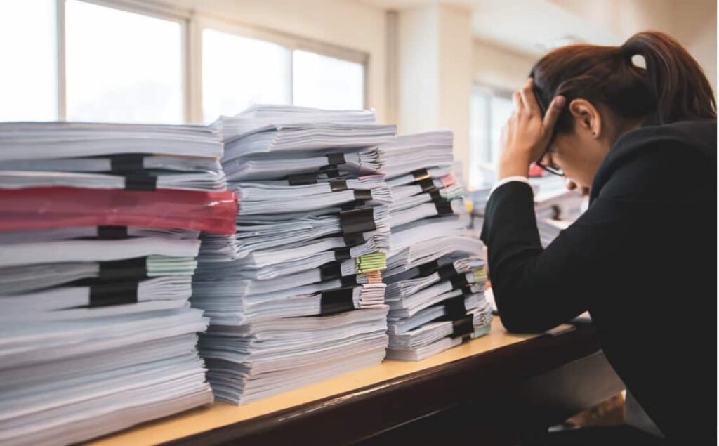 A stressed woman reviews paperwork.