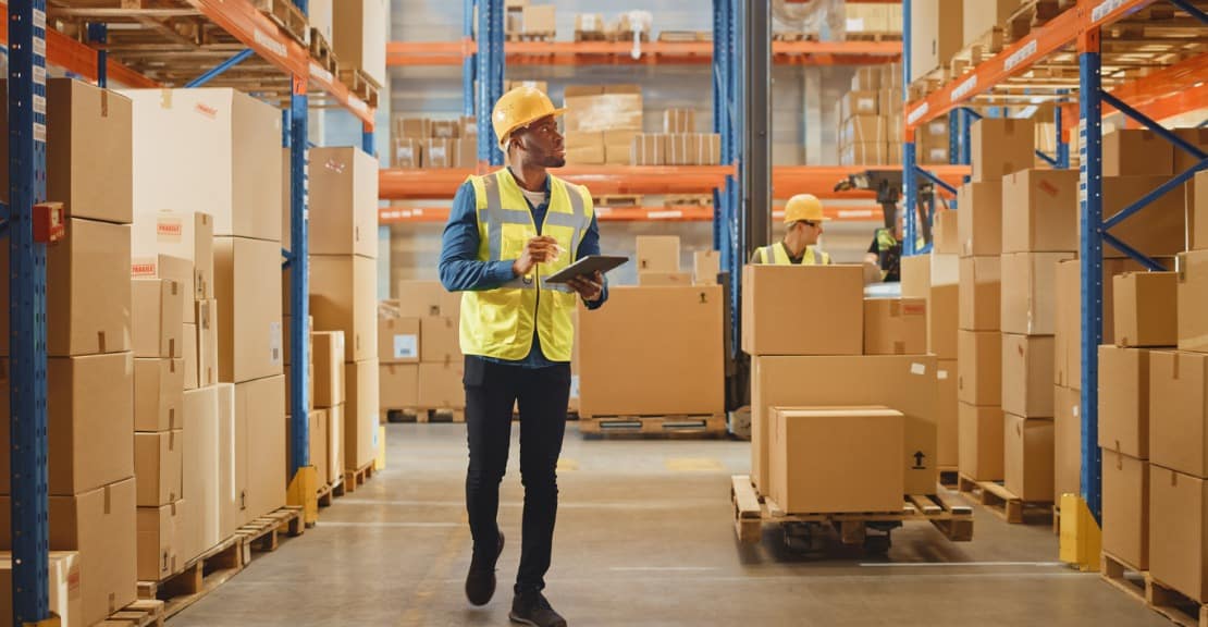 A warehouse employee practices warehouse management on a tablet.