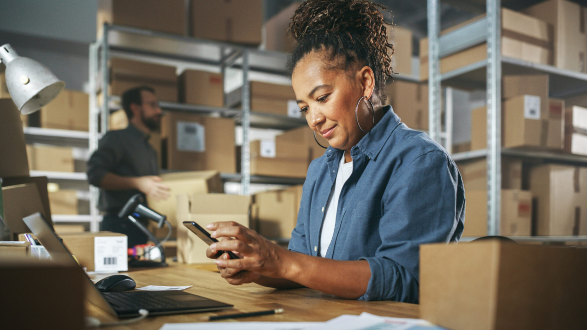 A woman practices supply inventory management while holding a smartphone.