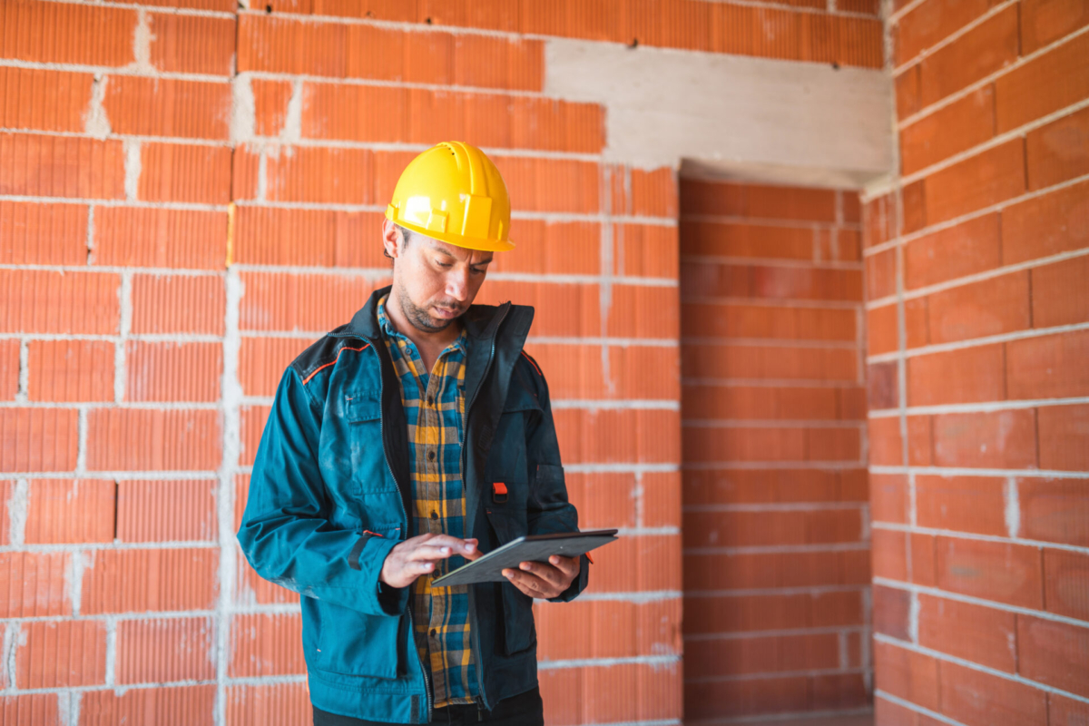 Construction worker tracking inventory on a tablet.