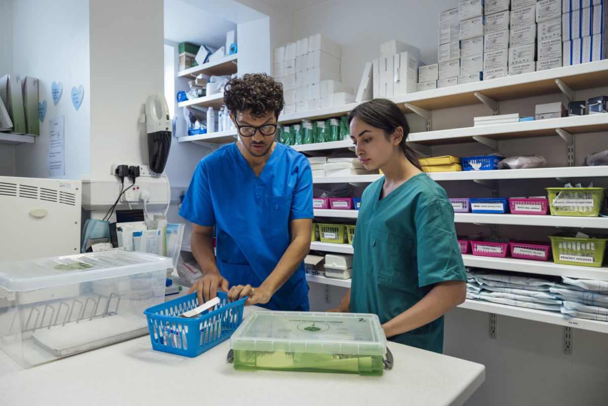Employees discussing medical supply storage ideas in scrubs.
