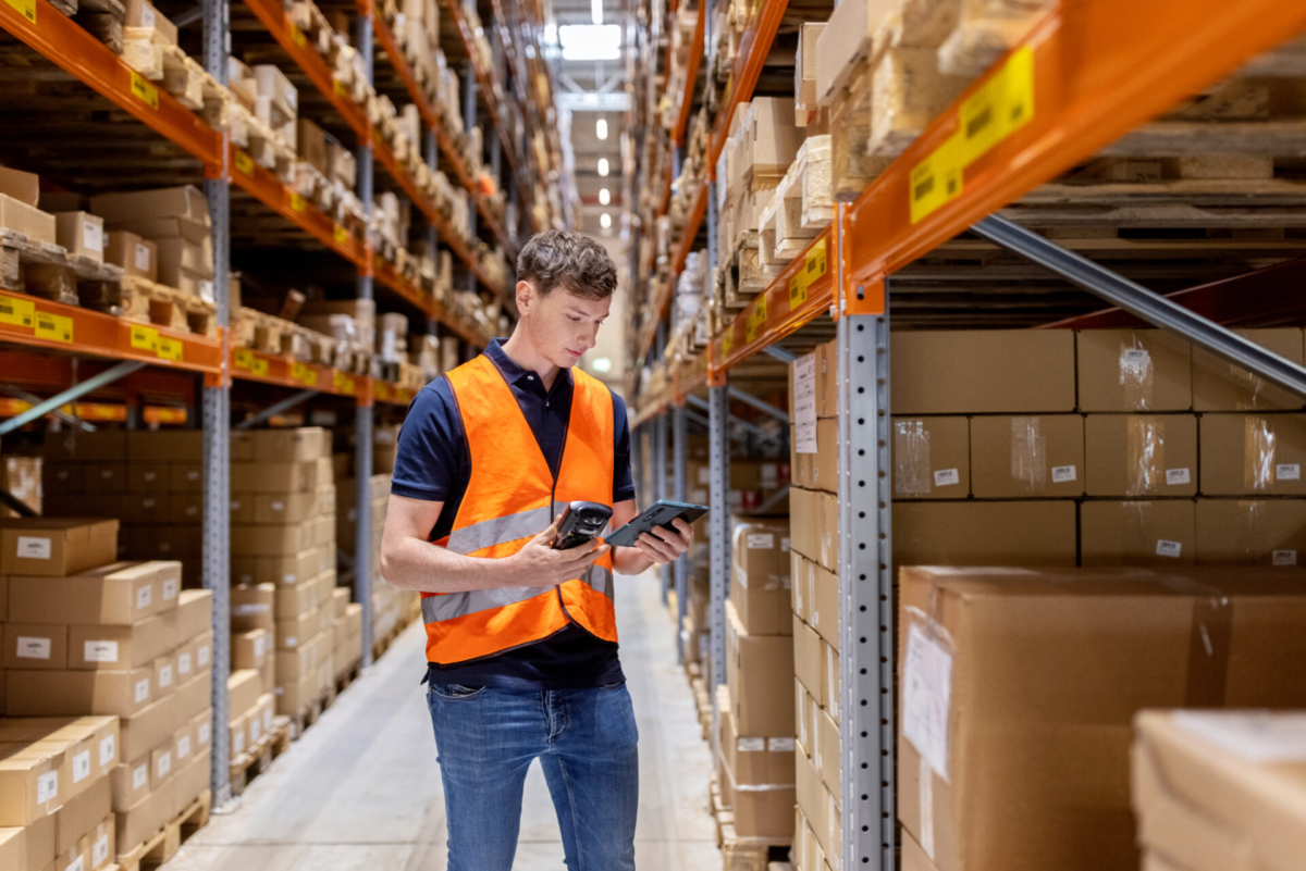 Employee deciding between handheld scanner or mobile inventory app.