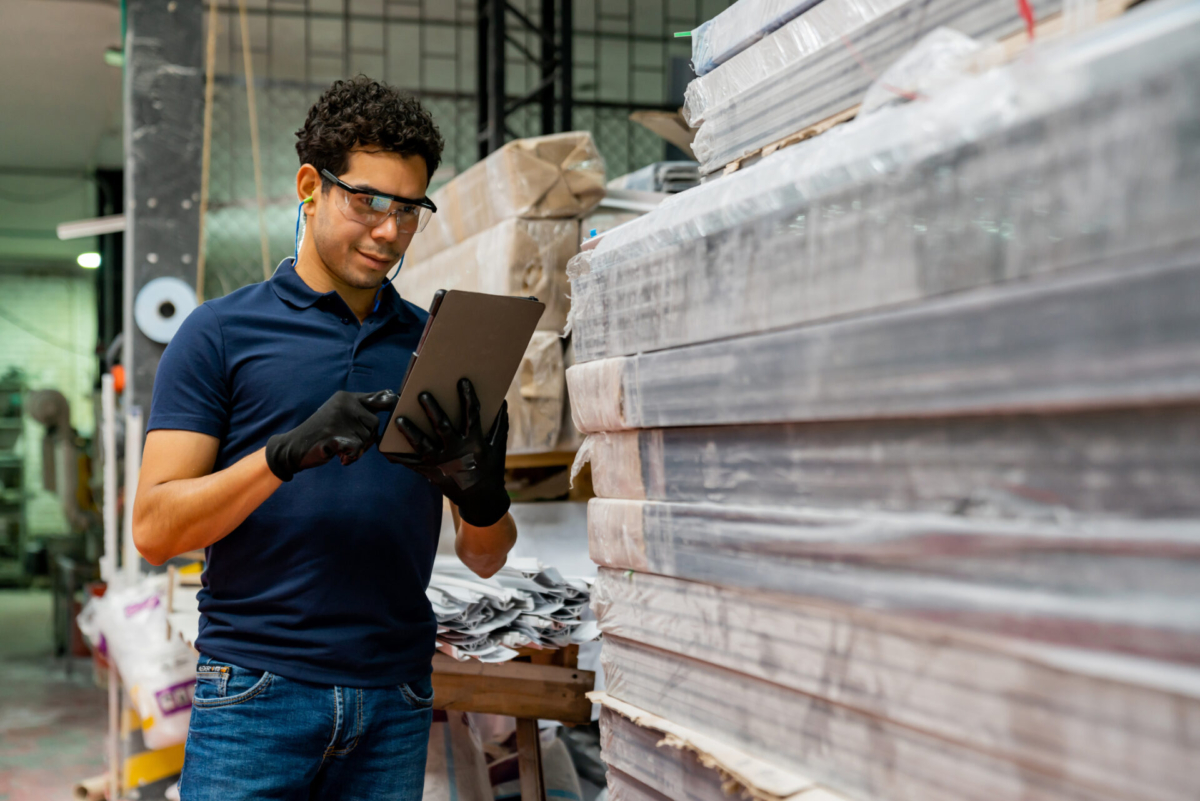 Male employee in warehouse practicing supply chain inventory optimization
