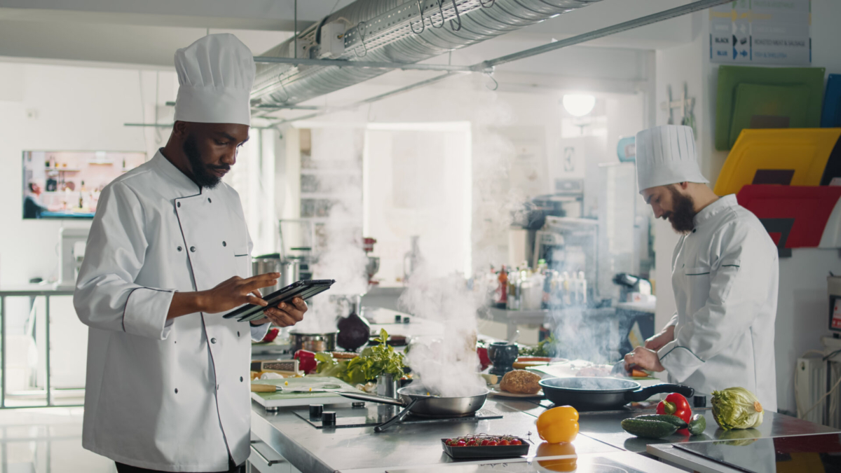 Chef managing inventory on tablet in kitchen