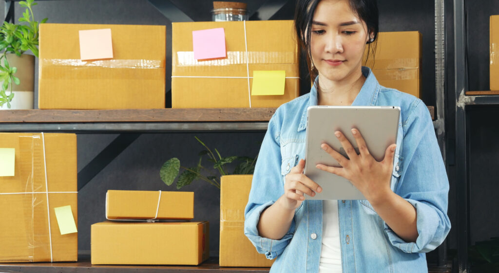 A woman uses inventory management software on a tablet.