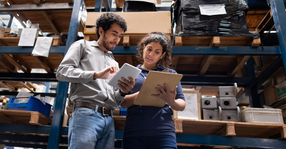 Inventory analysis is conducted by two team members in a warehouse.