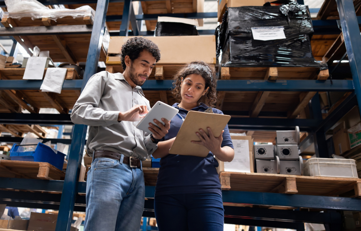 Inventory analysis is conducted by two team members in a warehouse.