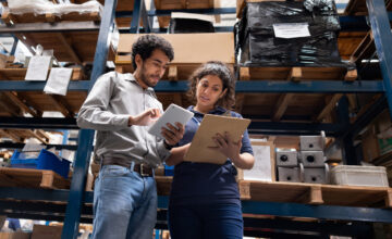Inventory analysis is conducted by two team members in a warehouse.