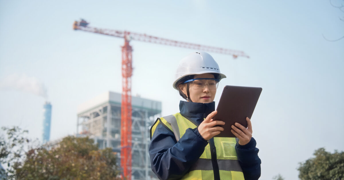 A woman uses a tablet for better construction asset management.