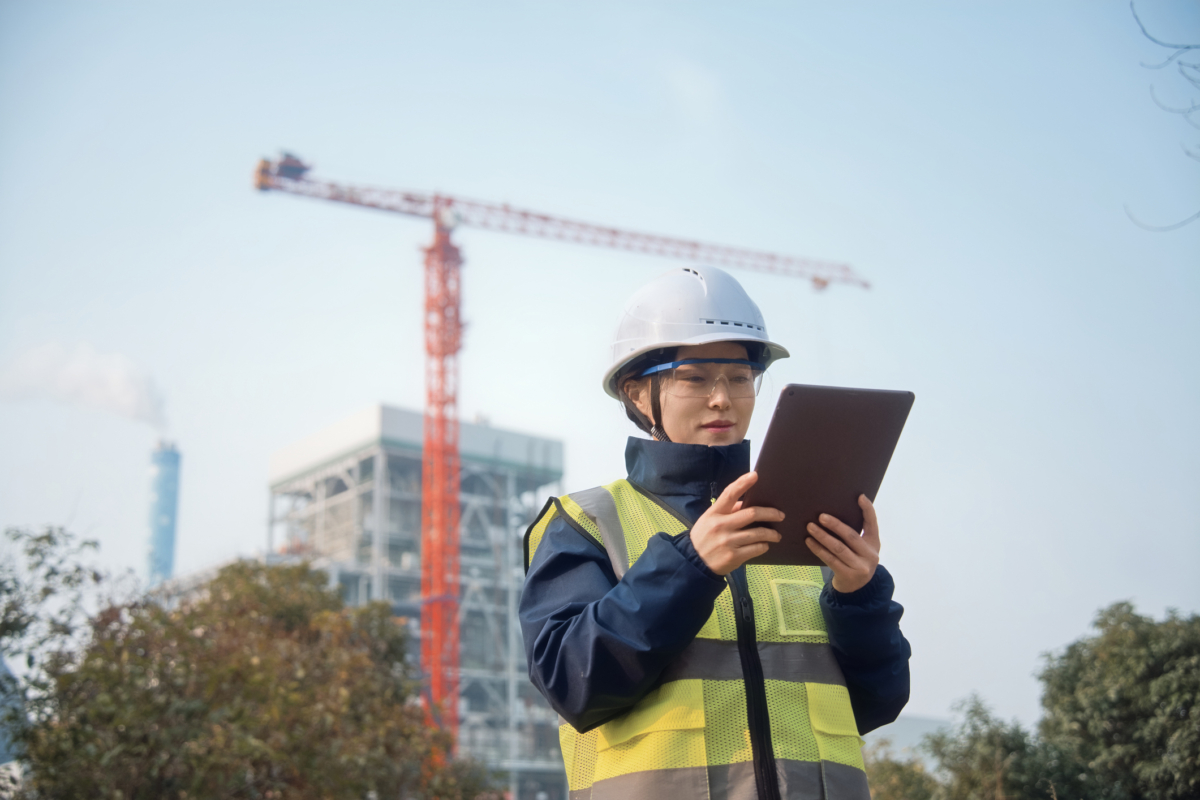A woman uses a tablet for better construction asset management.