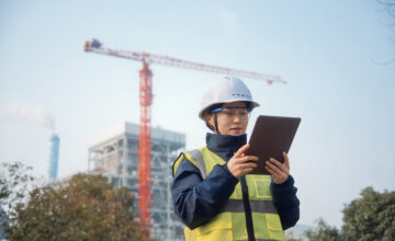 A woman uses a tablet for better construction asset management.