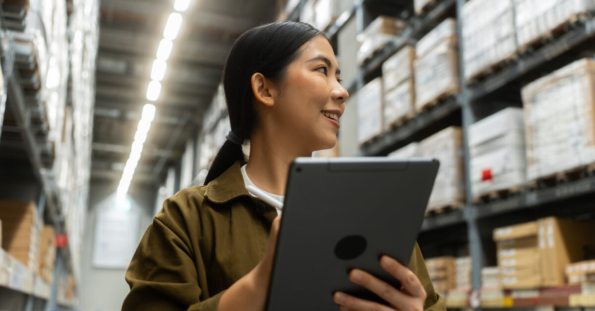 A woman uses warehouse management software on a tablet.