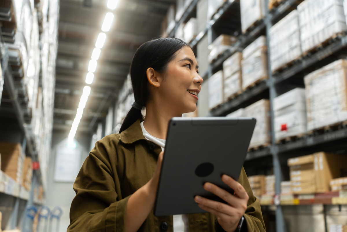 A woman uses warehouse management software on a tablet.
