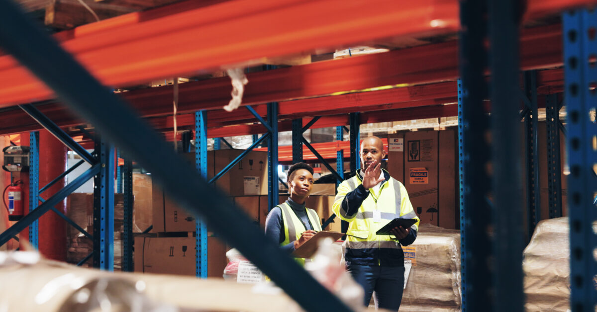 Two employees use warehouse management software.