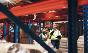 Two employees use warehouse management software.