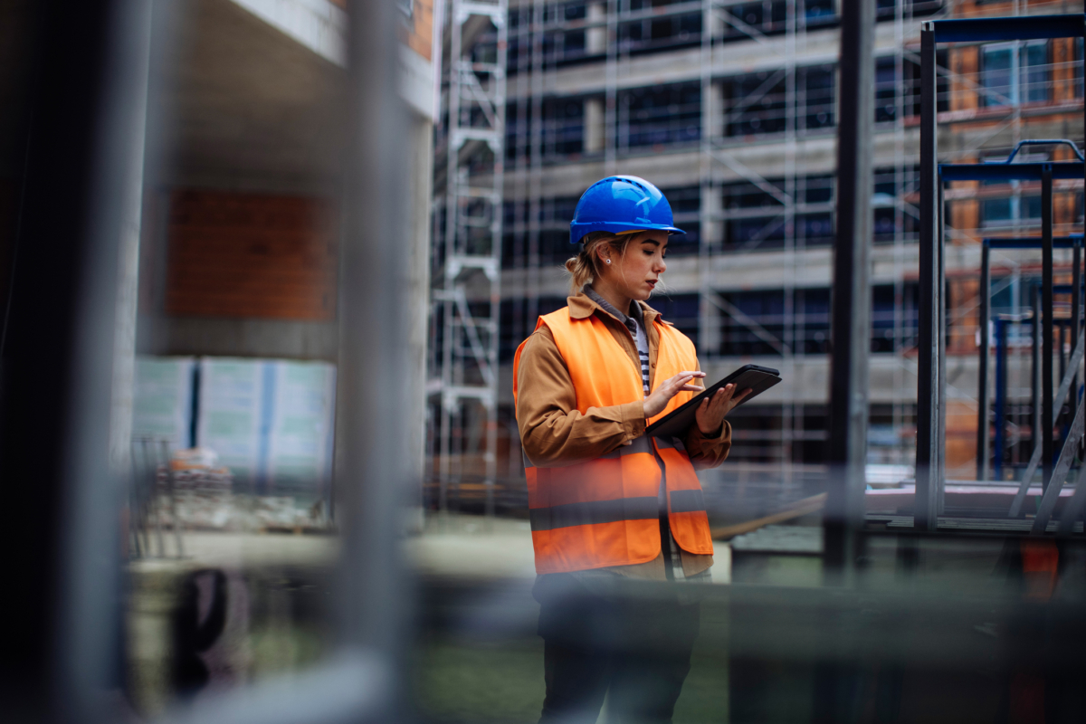 An employee manages construction equipment on a tablet.