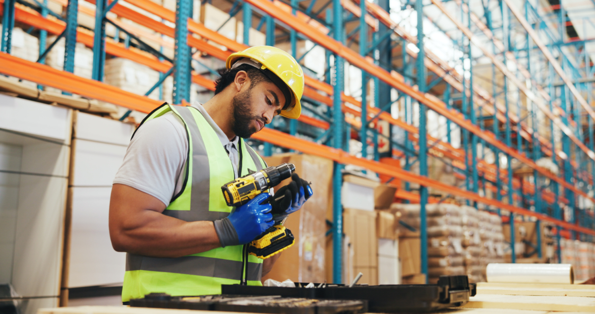 Man using drill in a warehouse