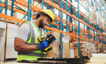 Man using drill in a warehouse
