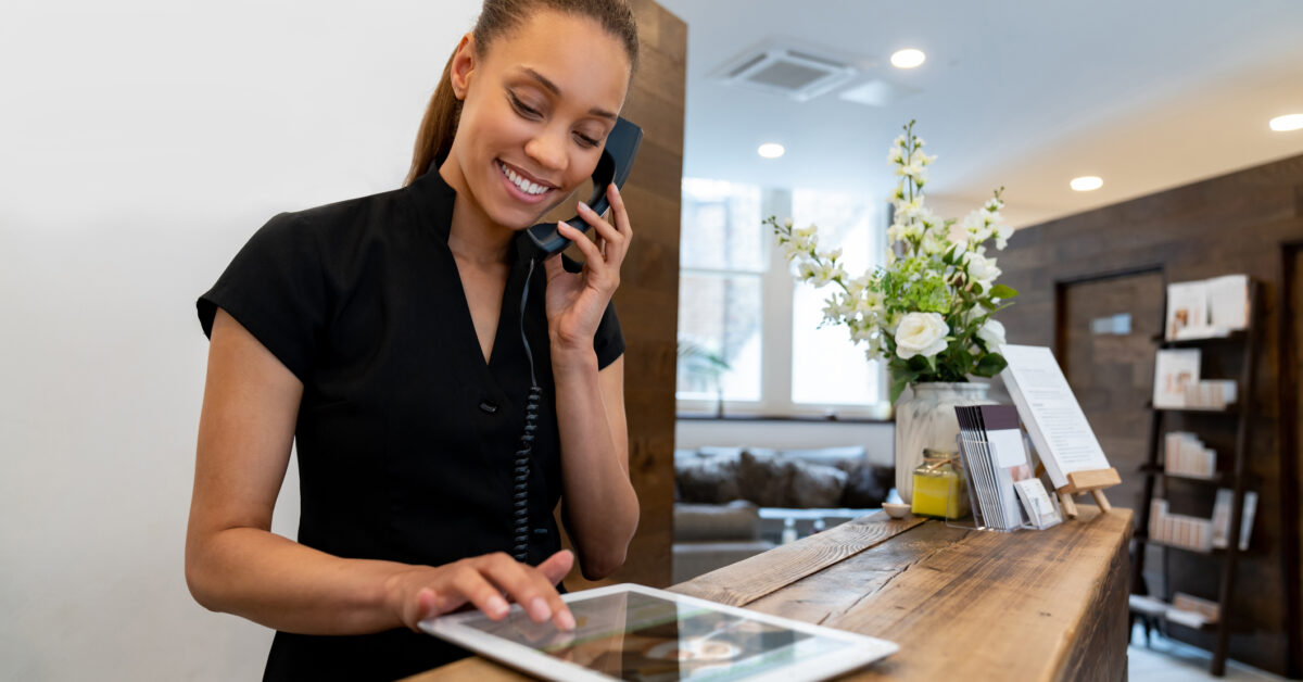 A woman uses a tablet for hotel inventory management.