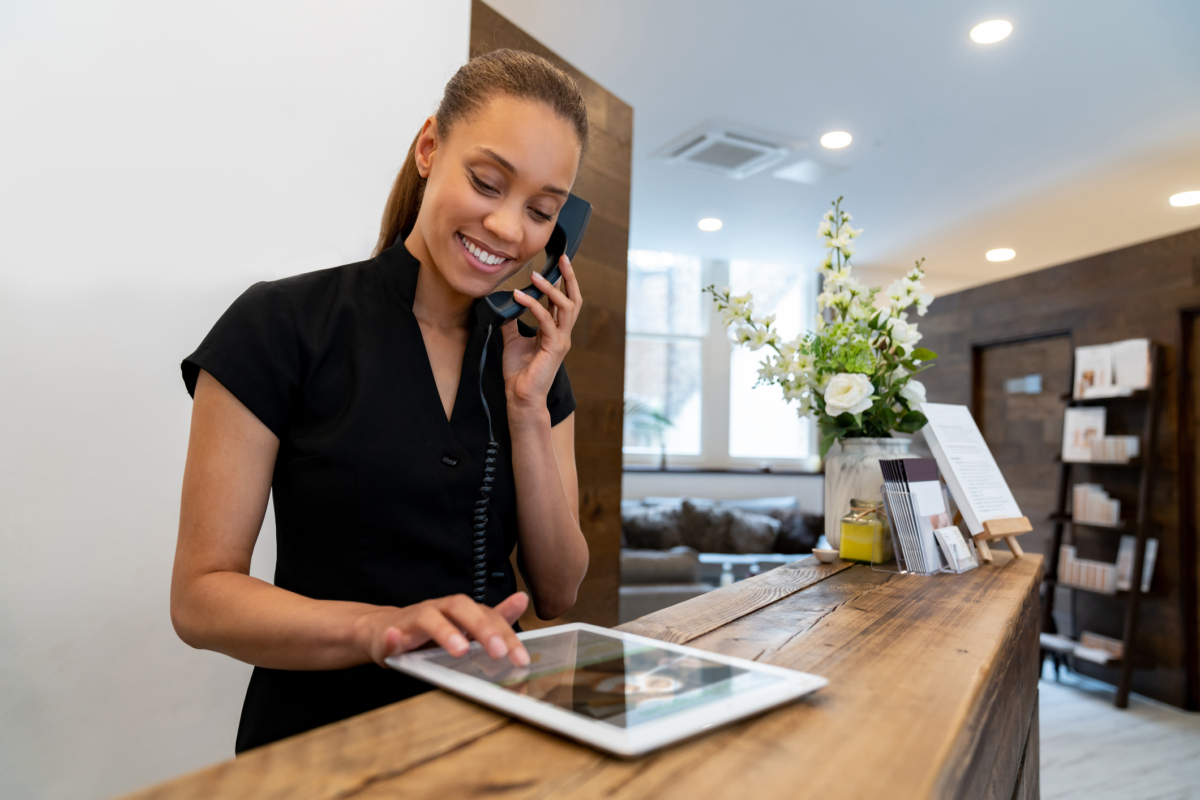 A woman uses a tablet for hotel inventory management.