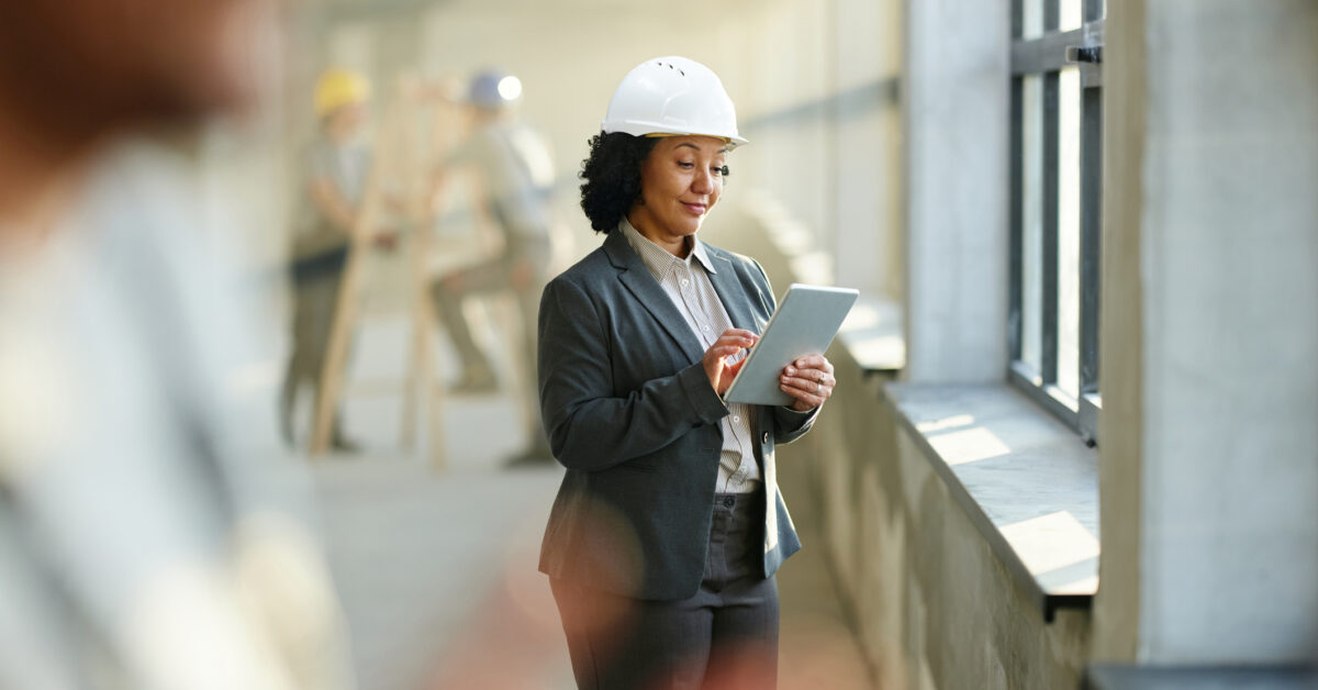 A woman uses fixed asset management software on a construction site.