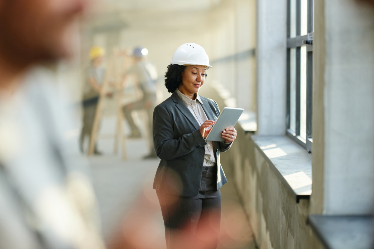 A woman uses fixed asset management software on a construction site.