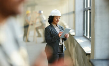 A woman uses fixed asset management software on a construction site.