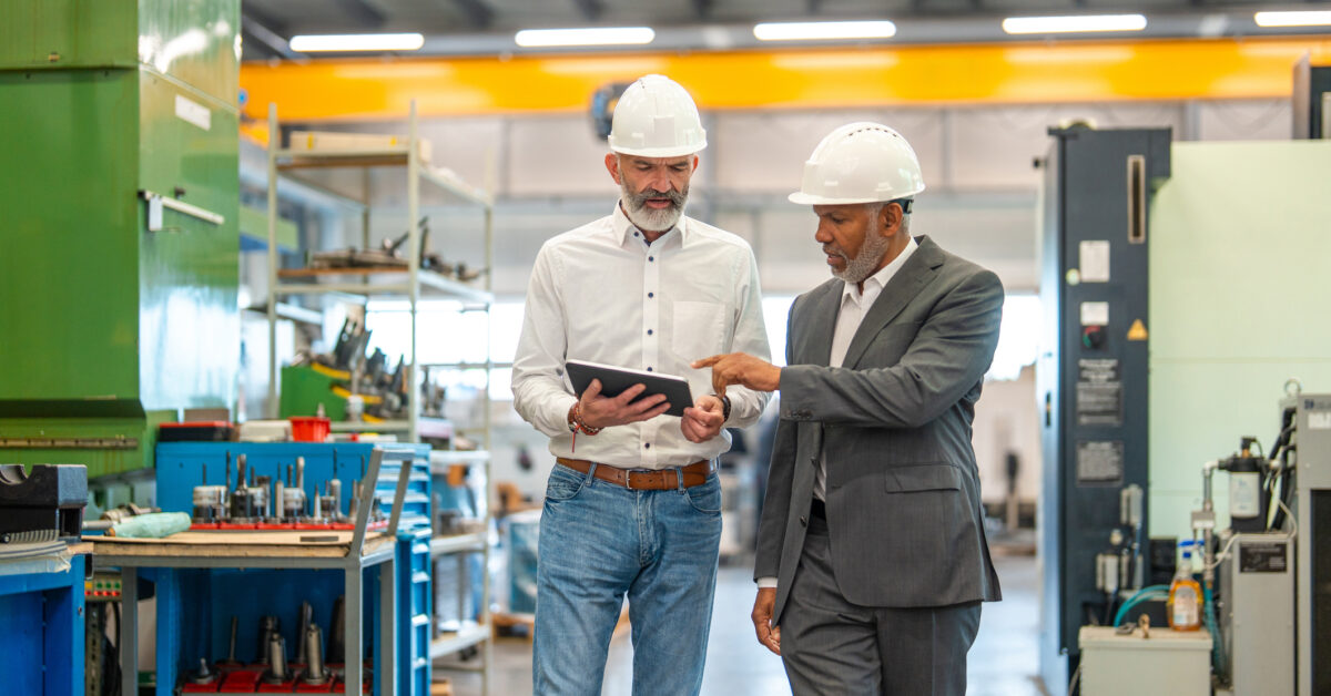 Two employees use a tablet for their company's asset management process.