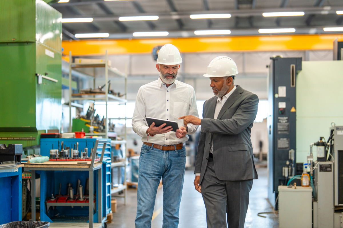 Two employees use a tablet for their company's asset management process.