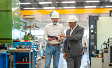 Two employees use a tablet for their company's asset management process.