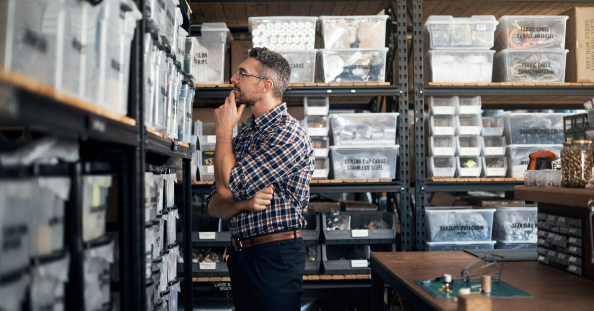 Small business owner looking at shelves, wondering if he needs to track inventory