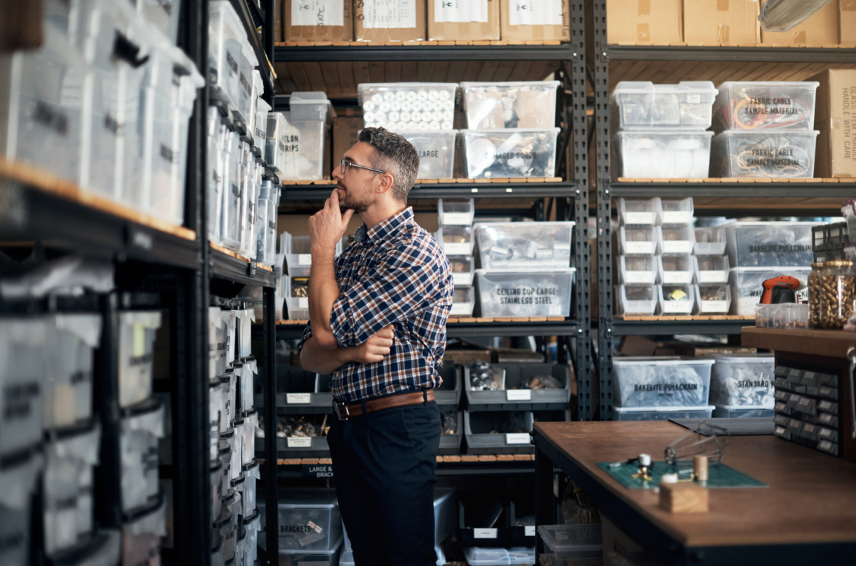 Small business owner looking at shelves, wondering if he needs to track inventory