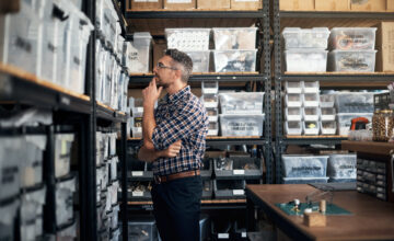 Small business owner looking at shelves, wondering if he needs to track inventory