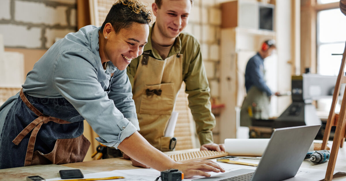 Two employees looking at computer in carpentry shop