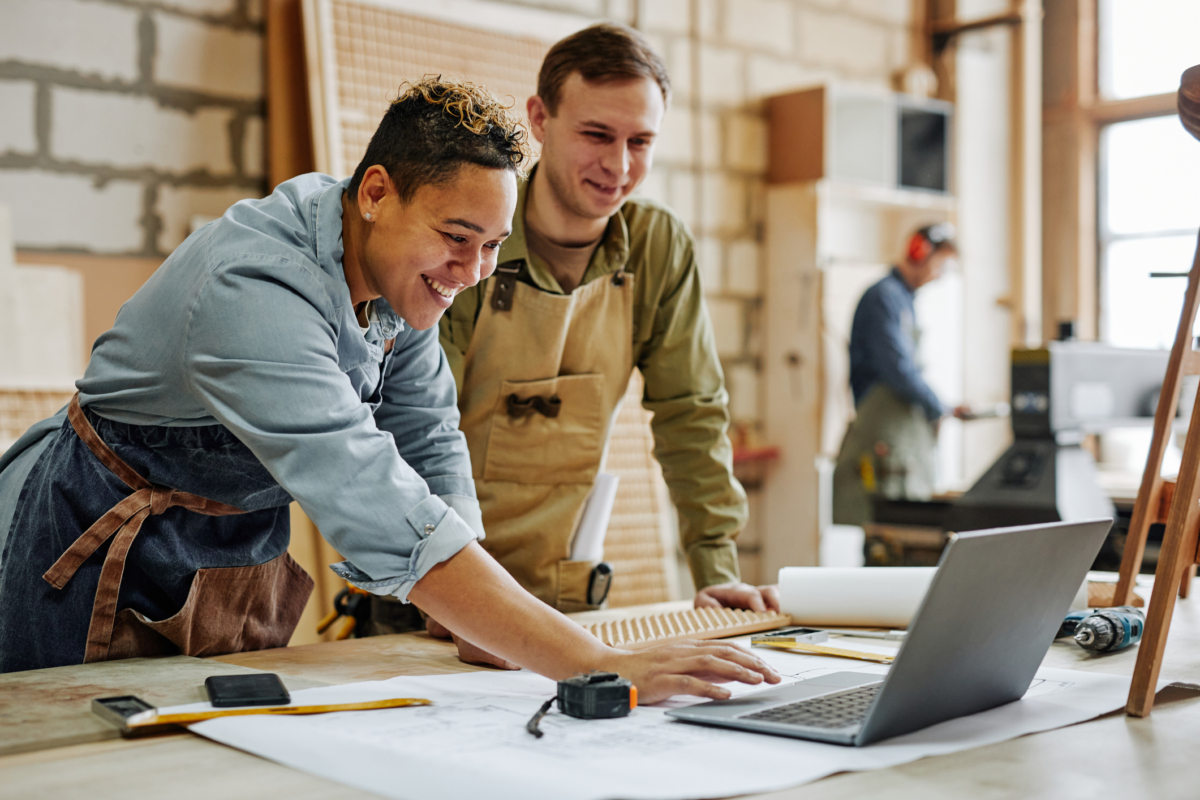 Two employees looking at computer in carpentry shop