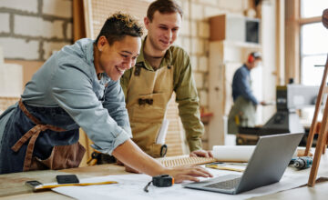 Two employees looking at computer in carpentry shop