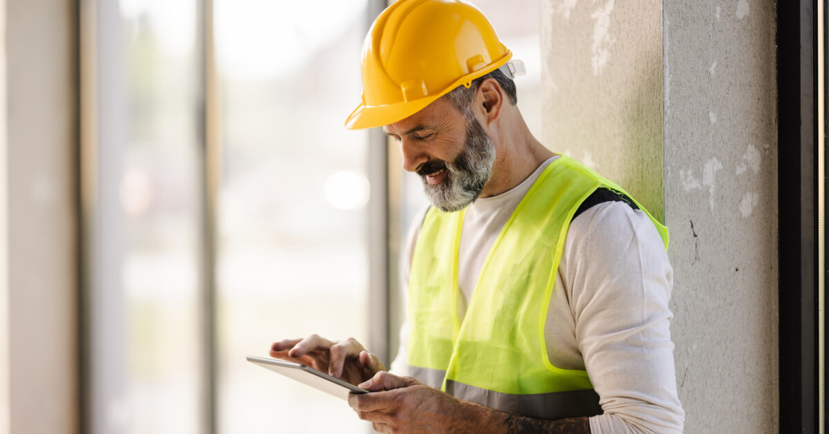 A man uses jobsite inventory management software on a construction site.