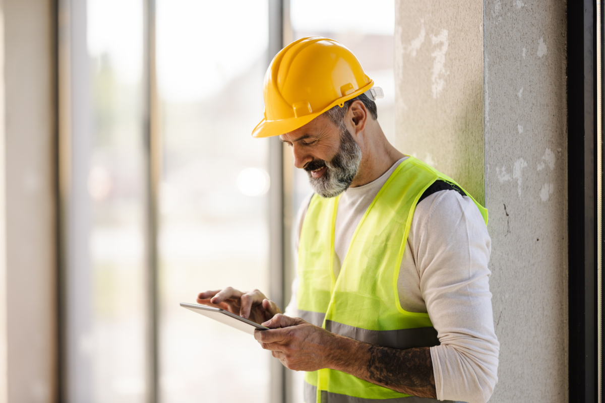 A man uses jobsite inventory management software on a construction site.