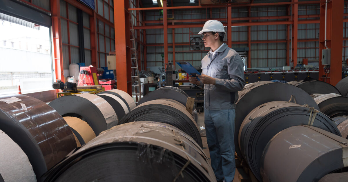 An employee uses a raw materials tracker in a warehouse.