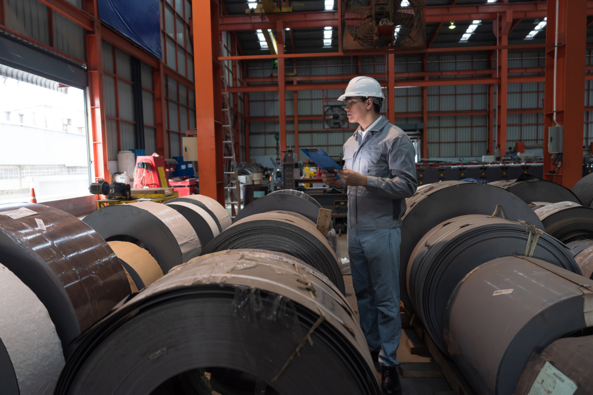 An employee uses a raw materials tracker in a warehouse.